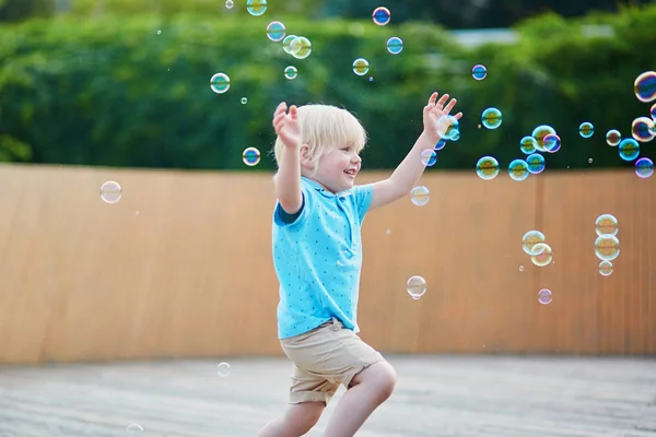 夏の日の屋外泡と遊ぶ幸せの愛らしい小さな男の子 — ストック写真