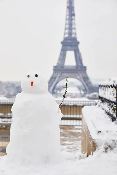 Sneeuwpop en Eiffeltoren op een dag met zware sneeuwval — Stockfoto