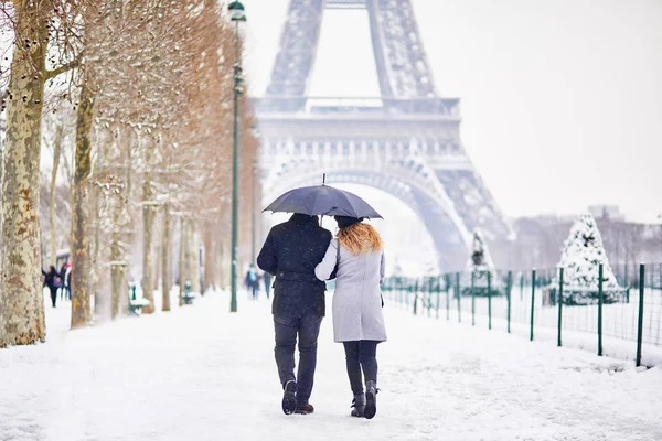 Pareja de turistas caminando en París en un día con nieve pesada — Foto de Stock