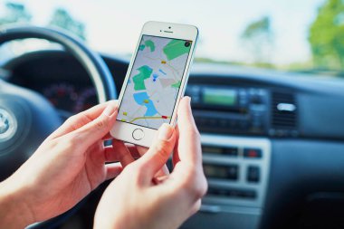 Kadın sürücü bir telefon arayüzü navigator ile bir ekran üzerinde tutan eller
