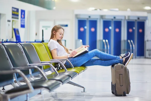 Νεαρή Γυναίκα Στο Διεθνές Αεροδρόμιο Διαβάζοντας Ένα Βιβλίο Κατά Την — Φωτογραφία Αρχείου