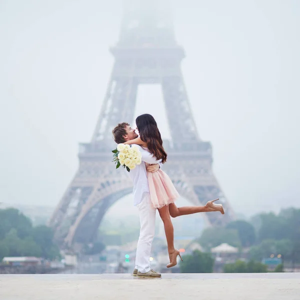 美丽浪漫的情侣 爱上了束白玫瑰附近埃菲尔塔在巴黎在云和雾的雨天 — 图库照片