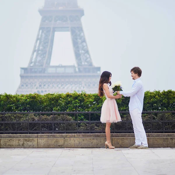 恋エッフェル塔近くの白バラの花束に美しいロマンチックなカップルは 曇りや霧の雨の日にパリのタワーします — ストック写真