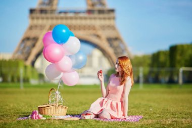 Fransa'nın Paris, Eyfel Kulesi yakınındaki piknik balonlar grup ile pembe elbiseli güzel genç kadın
