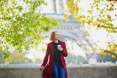 Güzel genç Fransız kadın Paris'te Eyfel Kulesinin yakınında bir Güz veya bahar gününde kahve içme