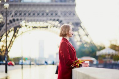 Güzel genç Fransız kadın Paris'te Eyfel Kulesinin yakınında bir Güz veya bahar gününde kahve içme