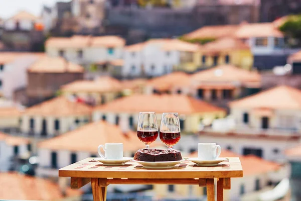 马德拉岛两杯酒 两杯新鲜咖啡和传统葡萄牙蜂蜜坚果甜点博洛德梅尔在咖啡馆与葡萄牙马德拉丰沙尔进城的视图 — 图库照片