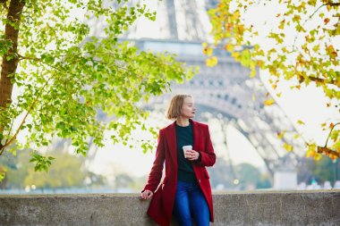 Güzel genç Fransız kadın Paris'te Eyfel Kulesinin yakınında bir Güz veya bahar gününde kahve içme