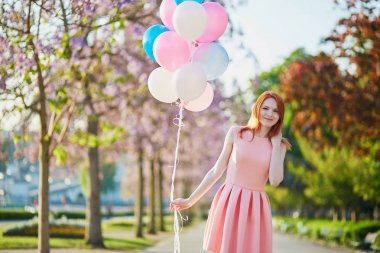 Mutlu genç kız grup bir bahar gününde Paris pembe ve mavi balonlar ile