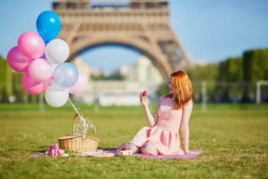 Fransa'nın Paris, Eyfel Kulesi yakınındaki piknik balonlar grup ile pembe elbiseli güzel genç kadın