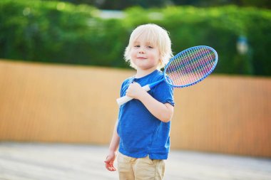 Sevimli küçük çocuk parkta badminton oynamaya. Çocuklar için açık yaz etkinlikleri