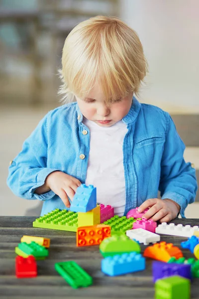 Очаровательный Мальчик Играет Красочными Пластиковыми Блоками Дома Детском Саду Детском — стоковое фото