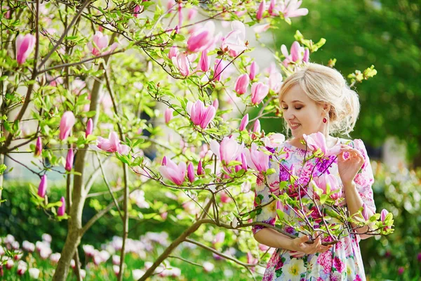 春の日に咲くモクレンの下で若い美しい女性 — ストック写真