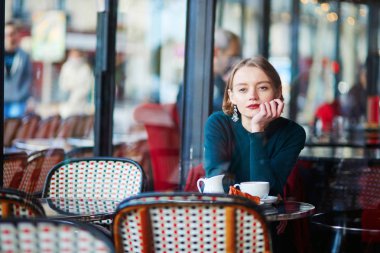 Kahve içme ve geleneksel Café Paris, Fransa'da cep telefonu kullanarak genç zarif kadın