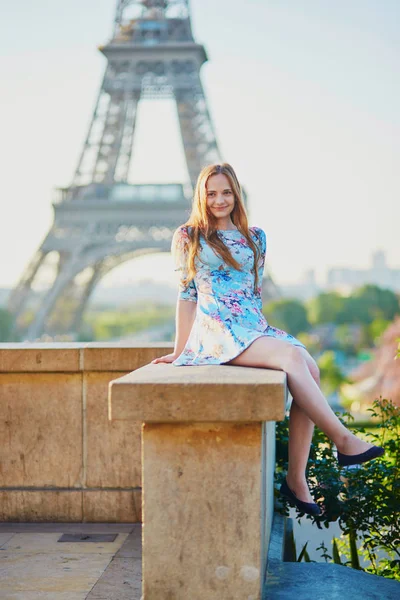 美丽的年轻女孩的埃菲尔铁塔附近的蓝色礼服享受她的时间在巴黎 — 图库照片