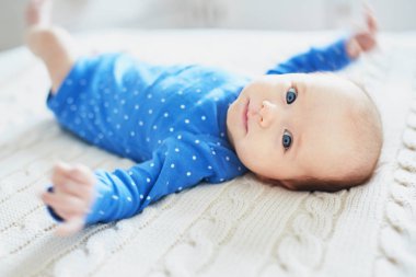 Çok güzel iki ay küçük kız mavi rahatlatıcı örme battaniye yatak odasında bir güneşli sabah kıyafetleri
