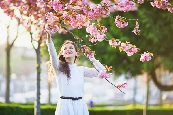 フランスのパリで桜の季節を楽しんでいる白いドレスで幸せな若い女 — ストック写真