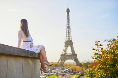 Fransa'nın Paris, Eyfel Kulesi yakınındaki beyaz elbiseli mutlu genç kadın
