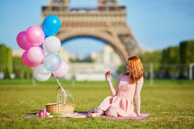 Paris'te Eyfel Kulesinin yakınında piknik balonlar grup ile pembe elbiseli kadın