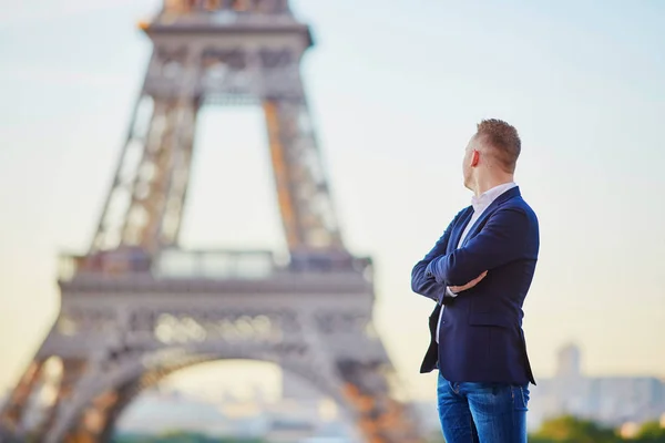 Handsome young man near the Eiffel tower — Stock Photo, Image