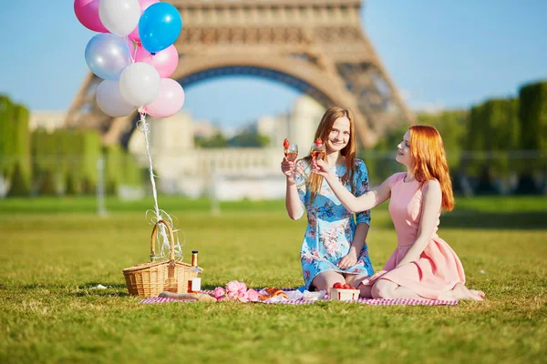 Två unga kvinnor att ha picknick nära Eiffeltornet i Paris, Frankrike — Stockfoto