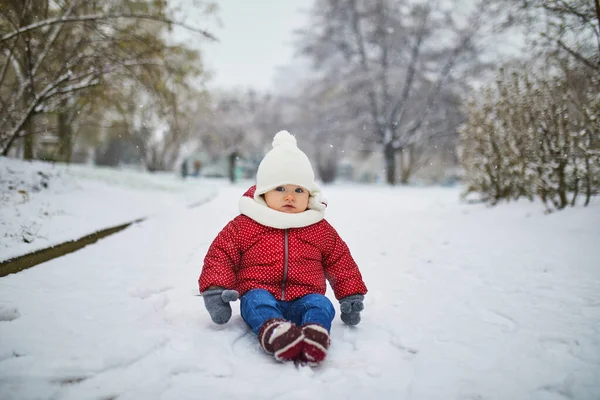 Glücklich lächelndes Baby Mädchen sitzt im Schnee — Stockfoto