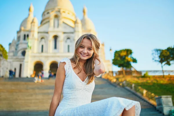 Krásná mladá žena sedí na schodech v blízkosti Sacre-Coeur katedrály v Paříži — Stock fotografie