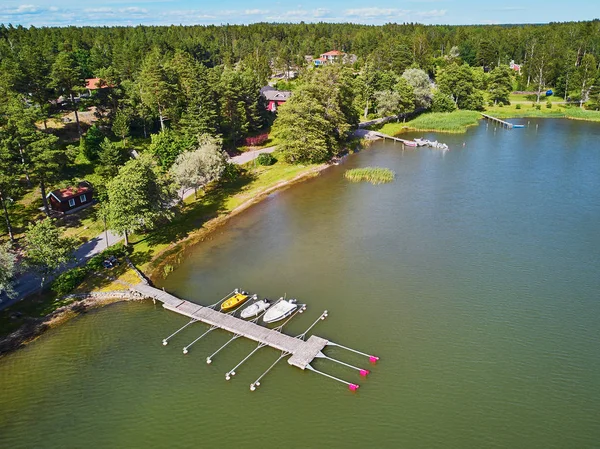 Vista aérea de barcos de colores cerca de amarradero de madera en el campo de Finlandia —  Fotos de Stock