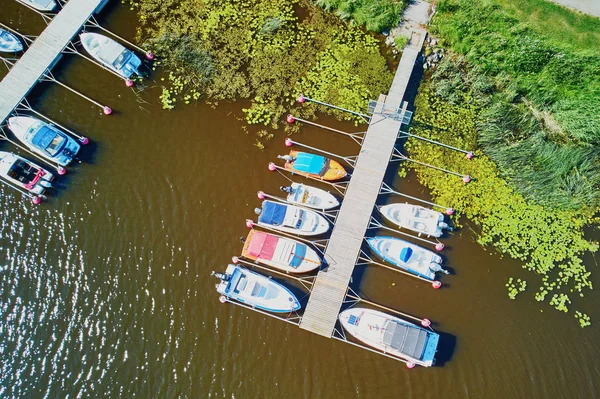 Bovenaanzicht van kleurrijke boten in de buurt van houten ligplaats op het platteland van Finland — Stockfoto