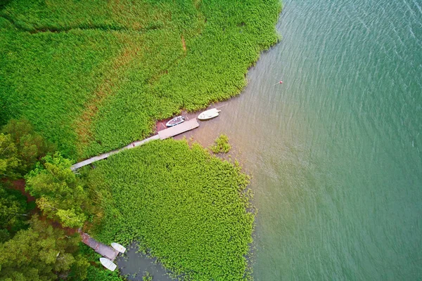 Vista aérea da casa do lago com beliche de madeira cercada por pinhal na zona rural da Finlândia — Fotografia de Stock
