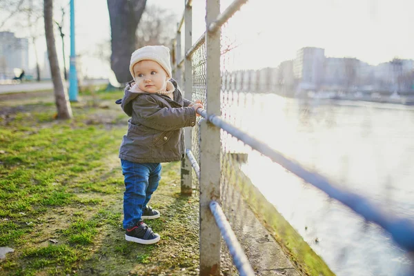 Jedna letnia dziewczyna stoi obok metalowego ogrodzenia w parku — Zdjęcie stockowe