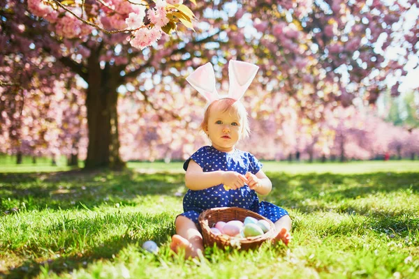 Linda chica de un año sentada en la hierba y comiendo fresas —  Fotos de Stock
