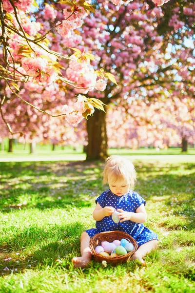Bonito menina de um ano sentada na grama e comer morangos — Fotografia de Stock