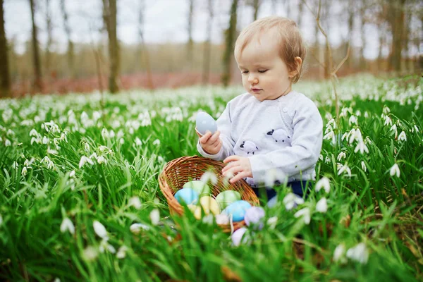 Linda niña de un año jugando a la caza de huevos en Pascua —  Fotos de Stock