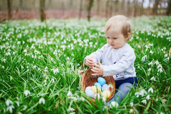 Schattige kleine een-jarige meisje spelen ei jagen op Pasen — Stockfoto