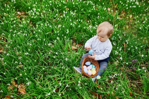 Linda niña de un año jugando a la caza de huevos en Pascua —  Fotos de Stock