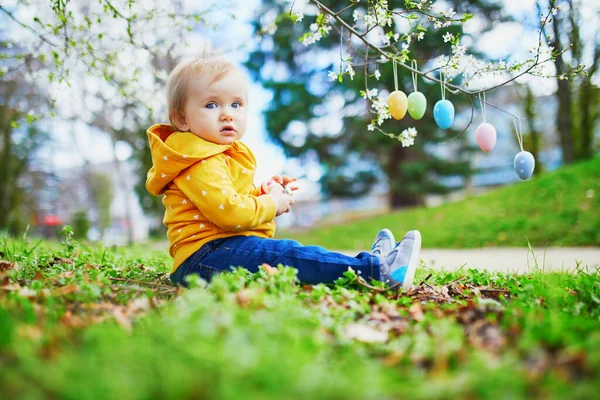 Cute little one year old girl playing egg hunt on Easter