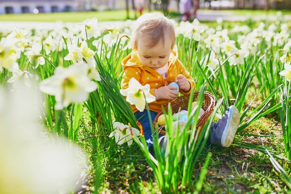 One year old girl playing egg hunt on Easter