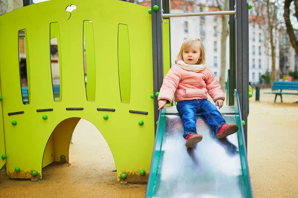 Adorable little girl on playground on a spring or fall day — Stock Photo, Image