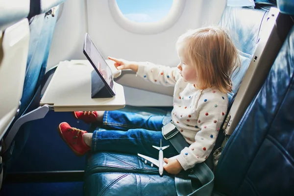 Adorable little toddler girl traveling by plane