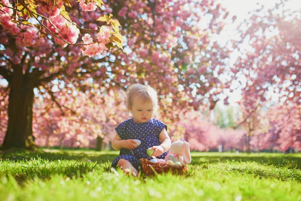 Carino una ragazza di un anno seduta sull'erba e mangiare fragole — Foto Stock