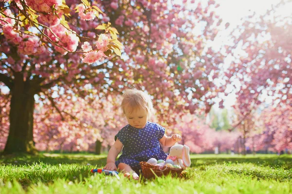 Süßes einjähriges Mädchen sitzt auf dem Gras und isst Erdbeeren — Stockfoto