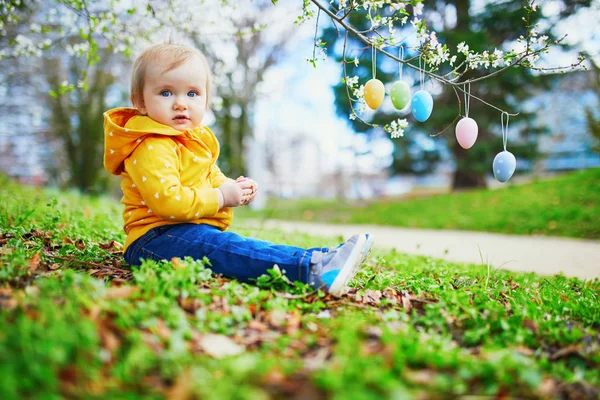 Niedliches kleines einjähriges Mädchen beim Ostereiersuchen — Stockfoto