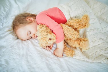En sevdiği oyuncakla yatan sevimli kız bebek. Küçük çocuk bir gün şekerleme yapıyor ve oyuncak ayıya sarılıyor. Kreşte dinlenen bebek çocuk