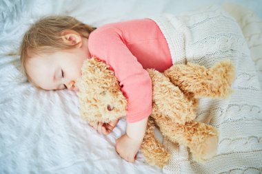 En sevdiği oyuncakla yatan sevimli kız bebek. Küçük çocuk bir gün şekerleme yapıyor ve oyuncak ayıya sarılıyor. Kreşte dinlenen bebek çocuk