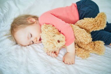 En sevdiği oyuncakla yatan sevimli kız bebek. Küçük çocuk bir gün şekerleme yapıyor ve oyuncak ayıya sarılıyor. Kreşte dinlenen bebek çocuk