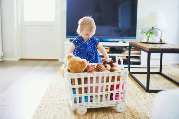 可爱的女婴在蓝色礼服玩玩具 小孩在家里玩得很开心 玩填充玩具的孩子 — 图库照片