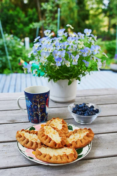 薄いライ麦粉で作られたカレリアンパイ Karjalanpiirakka ブルーベリーと朝食用のコーヒーカップを提供しています 伝統的なフィンランド料理 — ストック写真