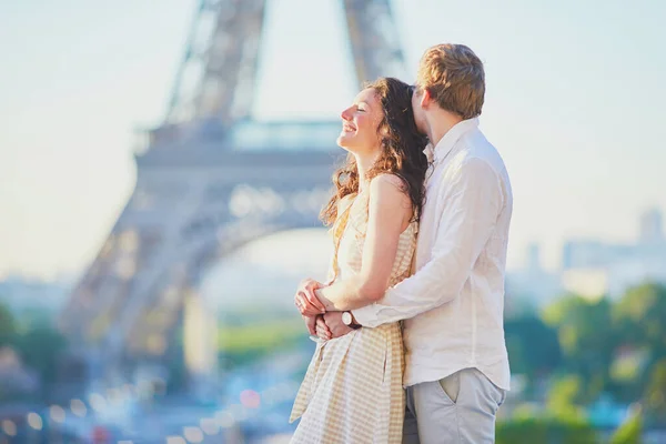 Happy romantic couple in Paris, near the Eiffel tower. Tourists spending their vacation in France