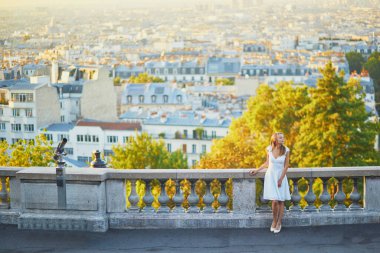 Güzel genç bir kadın Paris, Fransa manzarasının tadını çıkarıyor. Montmartre tepesinde beyaz elbiseli bir kız.